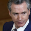 Headshot of Governor Gavin Newsom in a suit looking down and to his left