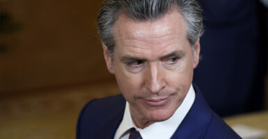Headshot of Governor Gavin Newsom in a suit looking down and to his left