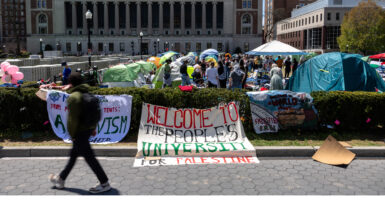 Pro-Palestinian protest sign and protesters on a university campus