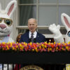 Joe Bien speaks in a suit with bunnies on his right and left