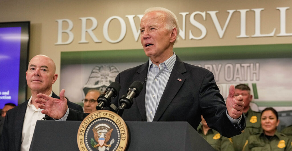 President Biden speaks at a podium near the border in Brownsville, Texas. Homeland Security Secretary Alejandro Mayorkas is in the background.
