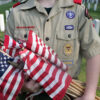 A Boy Scout holds flags to be placed on each grave at Zachary Taylor National Cemetery May 26, 2007 in Louisville, Kentucky.