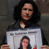 Rushan Abbas holds a photo of her abducted sister