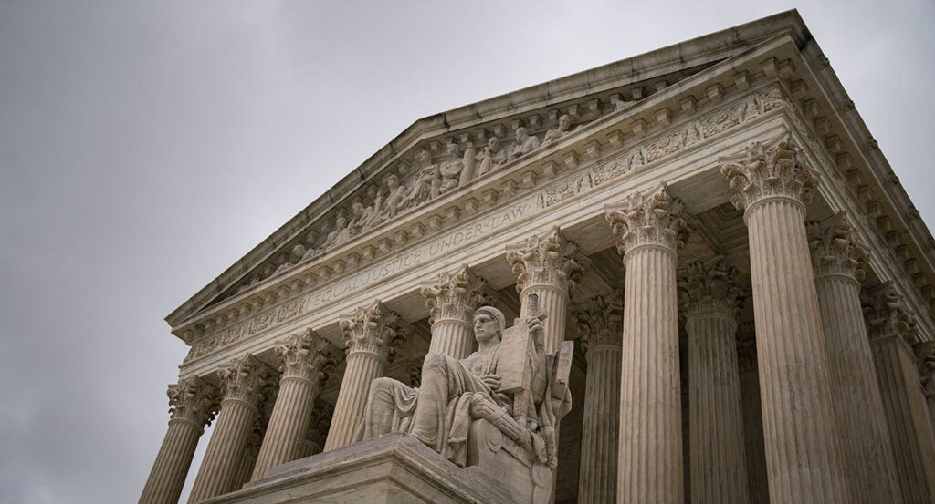 The front of the Supreme Court building with a statue of the authority of law