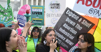 Pro-life and abortion protesters with their protest signs rally outside the Supreme Court