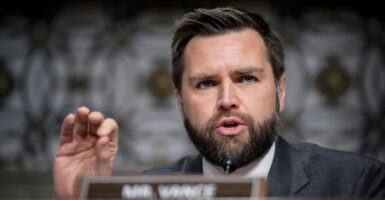 J.D. Vance gestures while wearing a suit