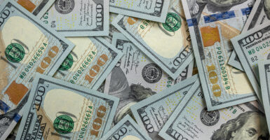 New U.S. $100 bills on black background.