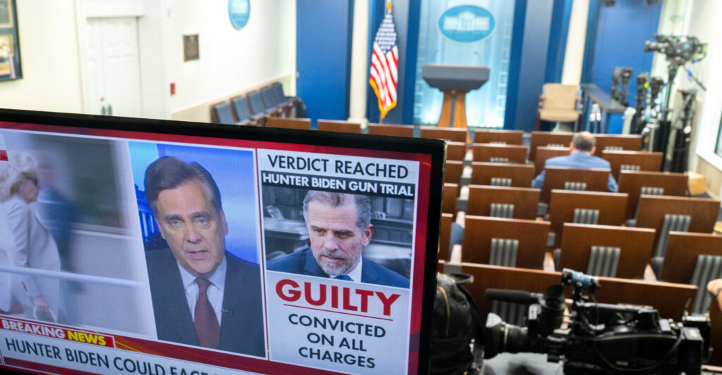 a TV screen in an empty White House press room shows a news report of Hunter Biden being found guilty on three gun charges