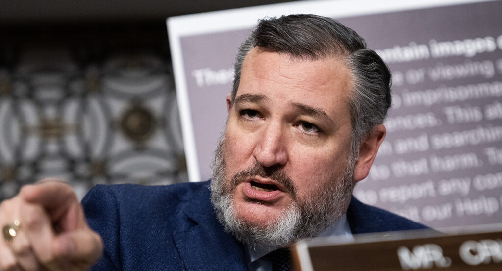 Ted Cruz, wearing a suit and a salt-and-pepper beard, points toward the audience at a congressional hearing
