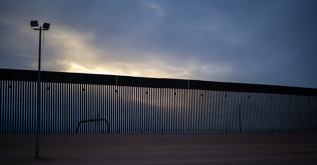 The sun sets behind the border wall in Texas.