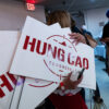 A woman holds campaign signs for Hung Cao.