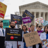 Doctors dressed in lab coats protesting in front of the Supreme Court in favor of abortion