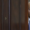 Joe Biden peeks out a door.