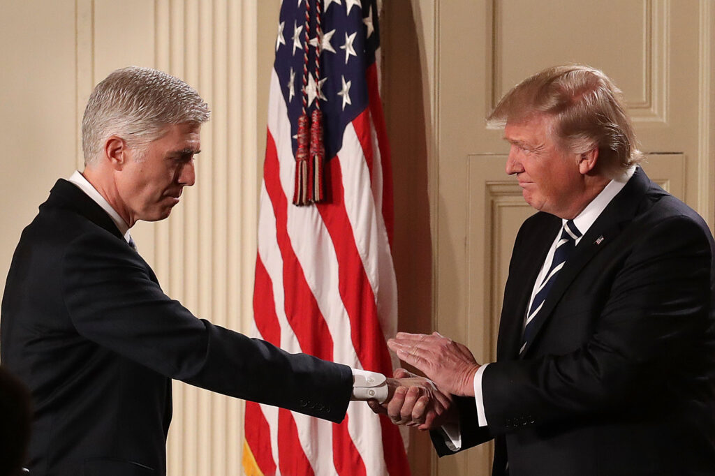 U.S. President Donald Trump (R) shakes hands with Judge Neil Gorsuch after nominating him to the Supreme Court during a ceremony in the East Room of the White House January 31, 2017 in Washington, DC. (Photo by Chip Somodevilla/Getty Images)