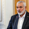 Hamas leader Ismail Haniyeh speaking in front of a microphone.