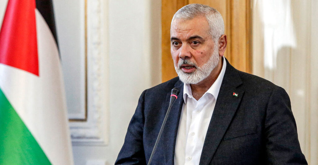 Hamas leader Ismail Haniyeh speaking in front of a microphone.