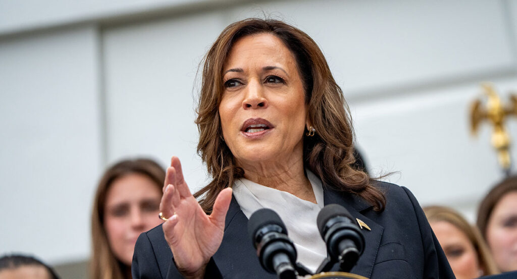 Kamala Harris gestures in front of a podium
