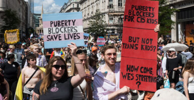 Protesters march with signs reading 