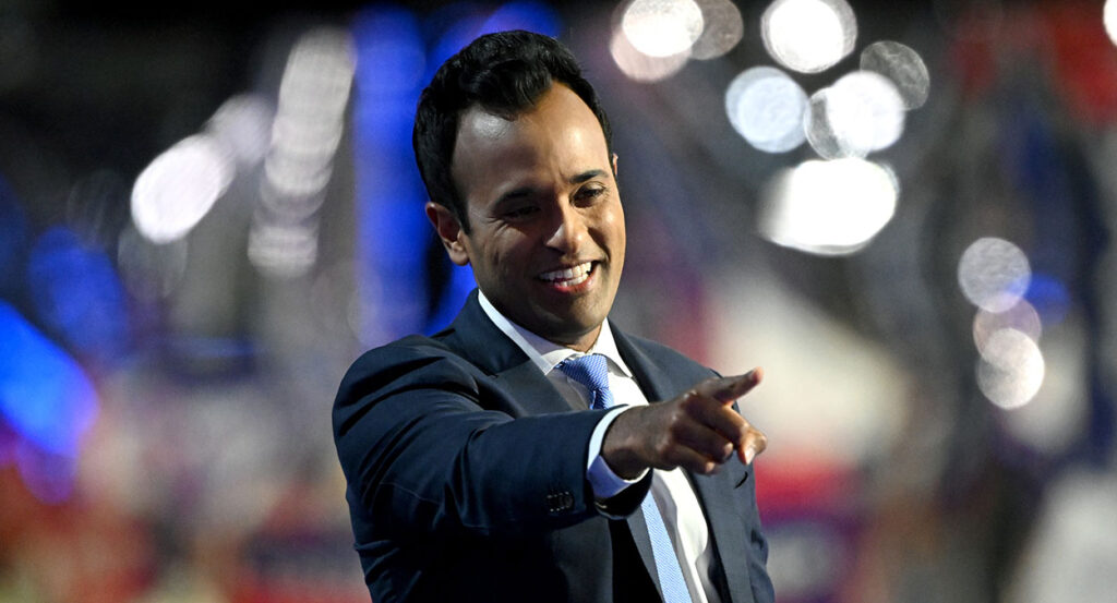 Vivek Ramaswamy in a suit points from the RNC stage