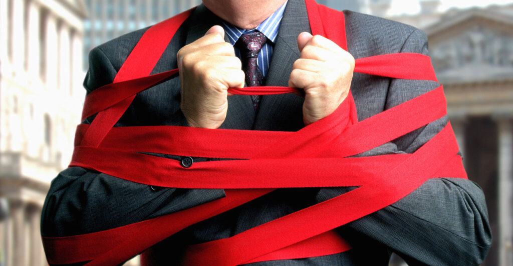 Businessman bound up in red tape