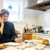 A female small business owner dealing with issues in the kitchen of her restaurant.