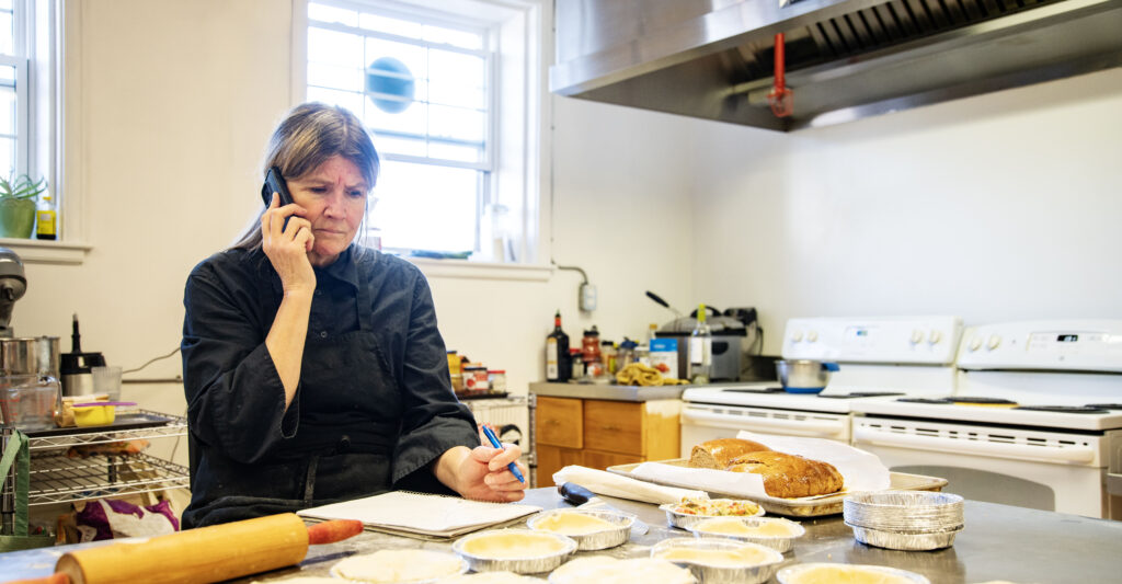 A female small business owner dealing with issues in the kitchen of her restaurant.