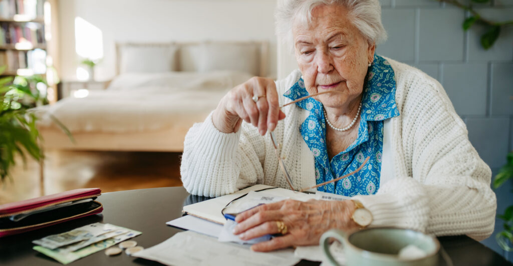 Senior woman calculates money and monthly pension.