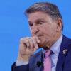 Joe Manchin rests his hand against his chin.