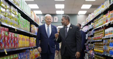 President Joe Biden walks with U.S. Representative Steven Horsford, D-Nevada, down a grocery store aisle.