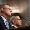 A side profile of Ronald Rowe sitting before a microphone during a hearing.