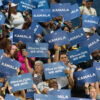 A crowd holds up signs that say "Kamala."