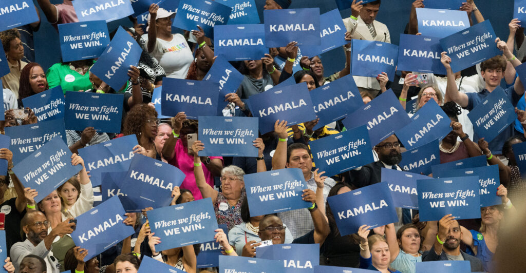 A crowd holds up signs that say "Kamala."