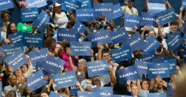 A crowd holds up signs that say 