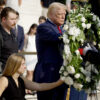 Donald Trump lays a wreath with two disabled veterans at the Tomb of the Unknown Soldier.