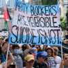 Protesters hold a sign reading, "Puberty Blockers Are Reversible, Suicide Is Not."