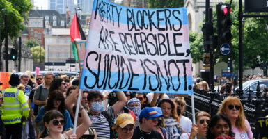 Protesters hold a sign reading, 