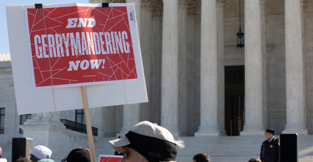 Protester holding a sign that says End Gerrymandering Now