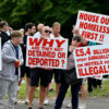 Protesters hold up signs against illegal immigration in Britain.