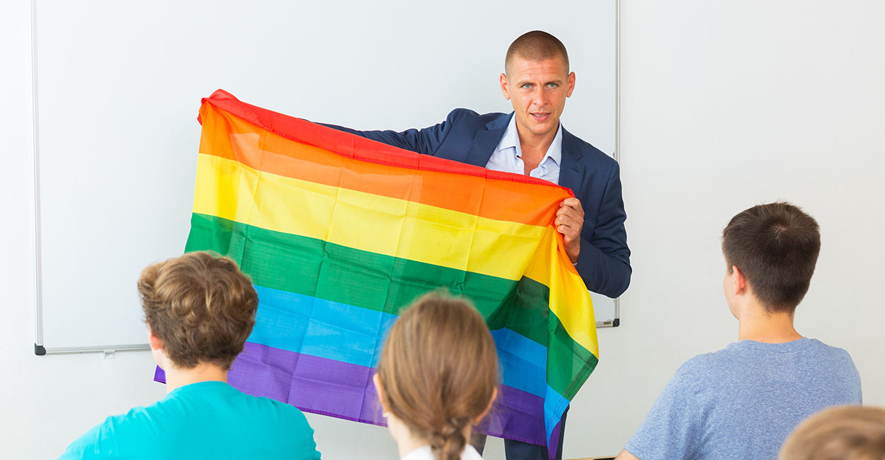 Teacher with LGBT rainbow flag in classroom
