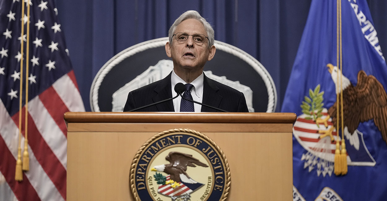 Attorney General Merrick Garland speaks at a podium with the words "Department of Justice"