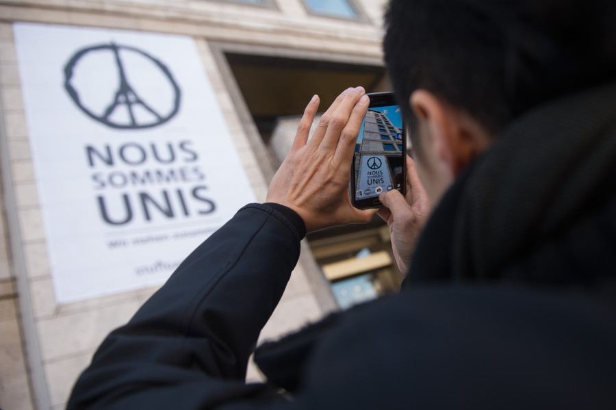 A giant poster, featuring a peace sign with the eiffel tower and the writing “Nous sommes unis” -- “we stand united” is hung on the wall of the town hall in Stuttgart, Germany. The image, by French artist Jean Julien, has gone viral since the attacks. (Photo: Marijan Murat/Newscom)
