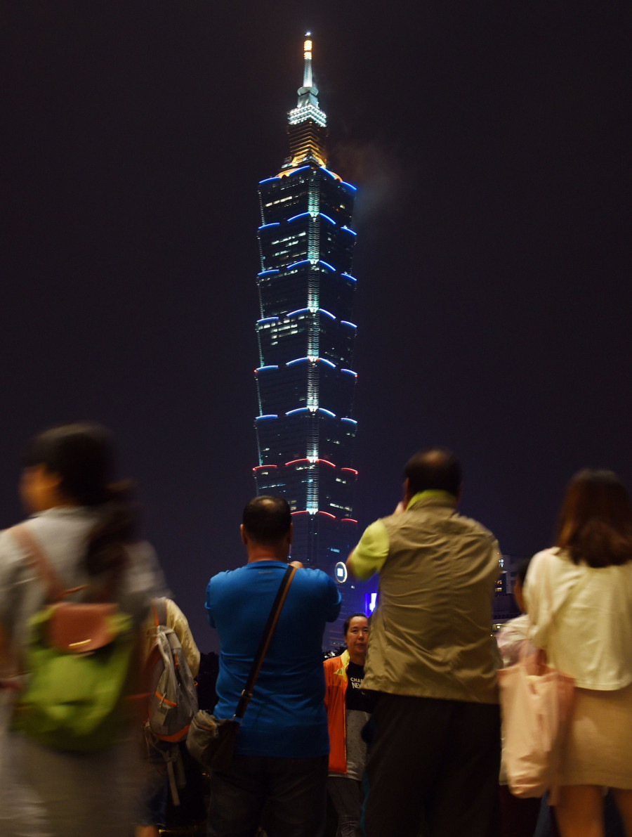 People watch the Taipei 101 building in Taipei, in southeast China Taiwan, light up with the colours of French national flag. (Photo: Xinhua/Wu Ching-teng/Newscom)