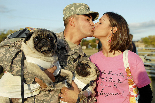 U.S. Army Spc. Leo Leroy gets a kiss from his wife and a welcome from his dogs Yoshi and Bruiser at a homecoming ceremony on Fort Hood, Texas, Nov. 28, 2009. Leroy returned after a year in Qayarrah in northern Iraq. (Photo: U.S. Army photo by Spc. Sharla Lewis)